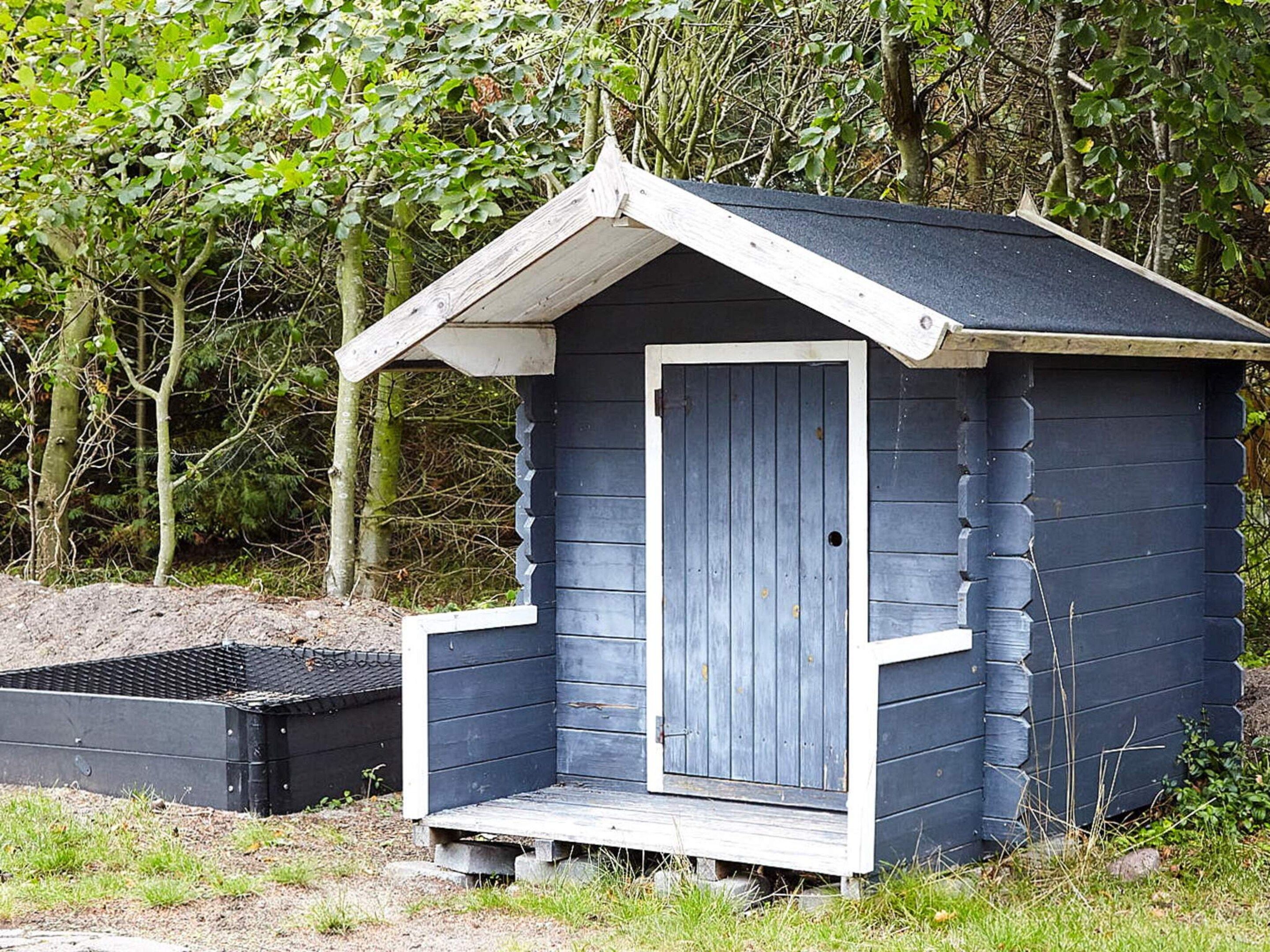 A small, single-room cabin with a sloped roof and a door.