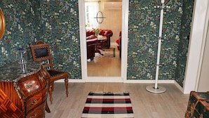 Una habitación con un escritorio de madera, un tapete estampado y un espejo.