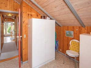 Cozy retreat with a sloped ceiling, wooden paneling, and a large wardrobe.