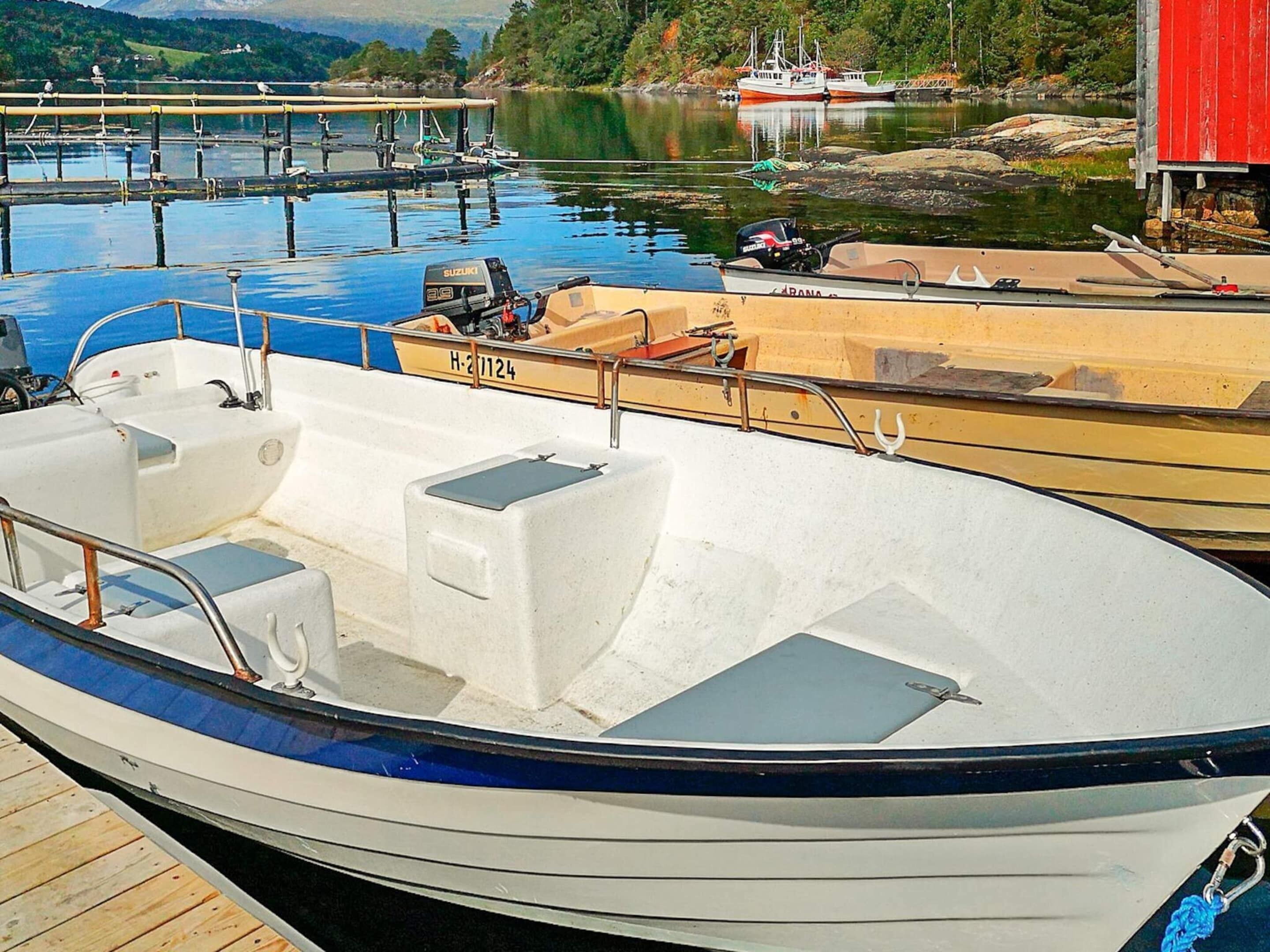 A boat docked at a marina with a clear view of the water and other boats in the background.