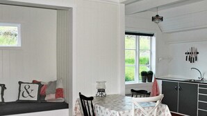 A dining area with a table, chairs, a bench, and a view of the outdoors. - 5 Person Holiday Home in Vagland (Heim)