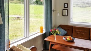 A cozy room with a wooden table, a bench, and a window overlooking a grassy area. - 4 Person Holiday Home in Bjoa (Vindafjord)