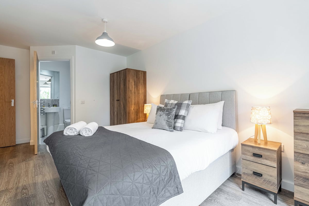 Une chambre bien rangée, avec un lit, des tables de chevet et une armoire.