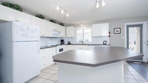Een moderne keuken met witte kasten, een granieten aanrechtblad en een ingebouwde oven.