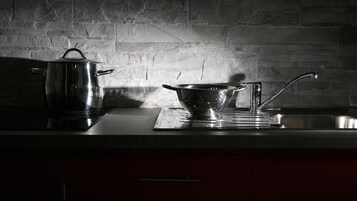 Una cucina con una pentola, un colapasta e un lavello su un piano di lavoro.