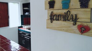 A kitchen with a window, cabinets, and a wall decoration of cacti and the word "family". - Mi espacio en Cancun (Cancun)