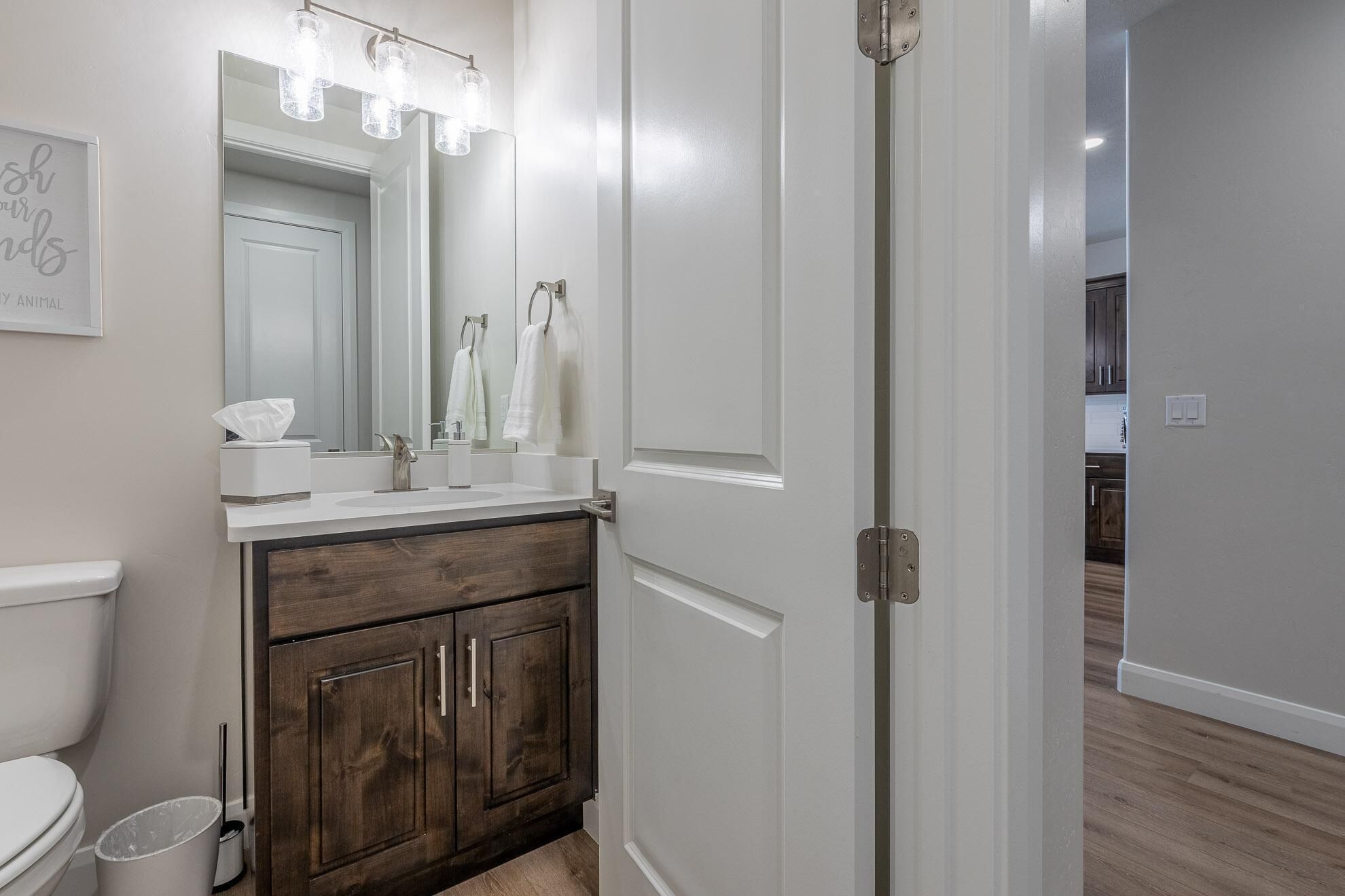 A bathroom with a white vanity, a large mirror, and a shower door.