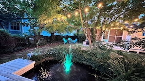 A pond with a fountain, surrounded by trees and outdoor seating. - Renovated Gem: Walk to Beach, Historic District Shops, Restaurants, Central Park (Cape Charles)