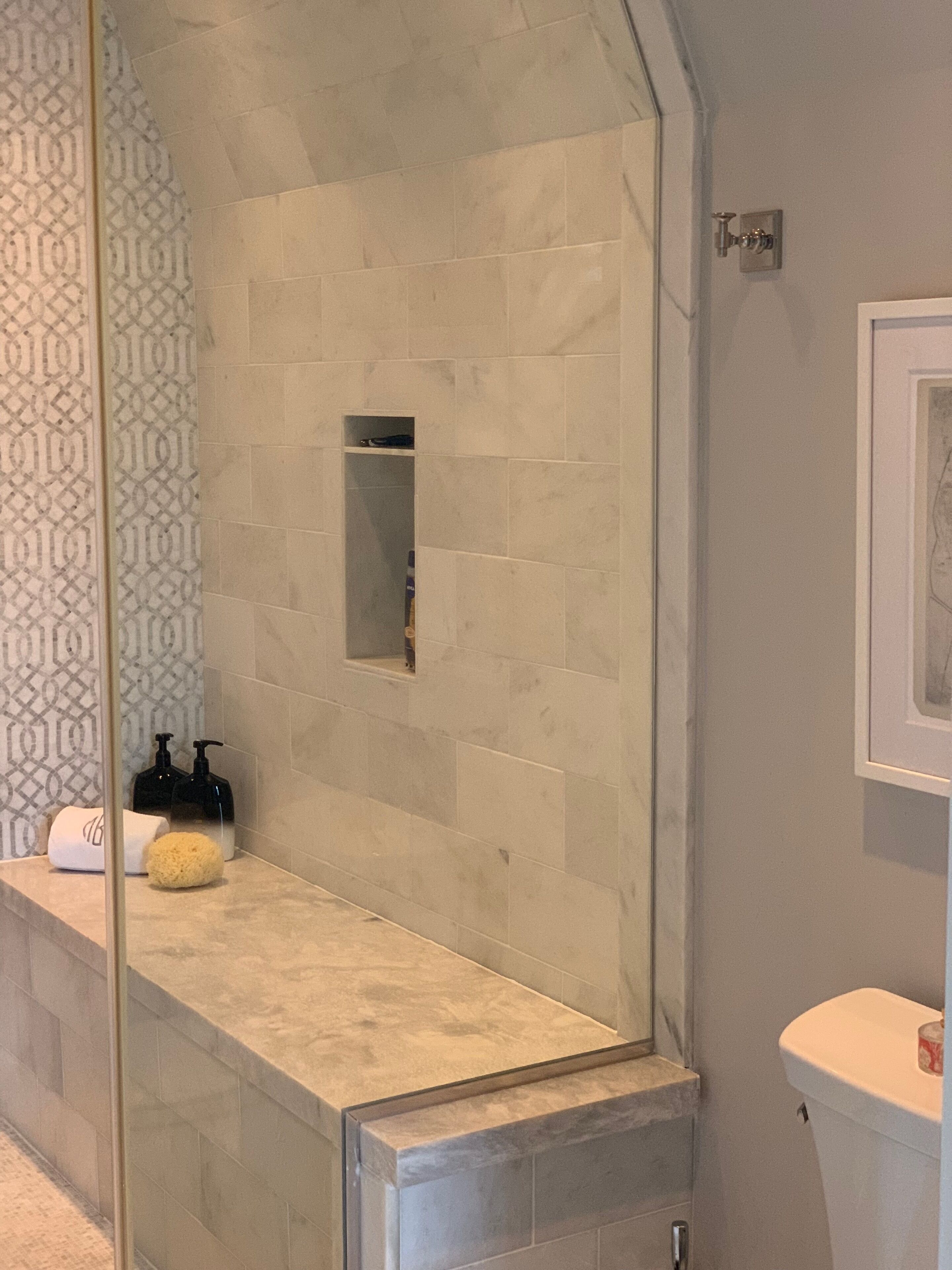 Un baño con zona de ducha, tocador con espejo y inodoro.