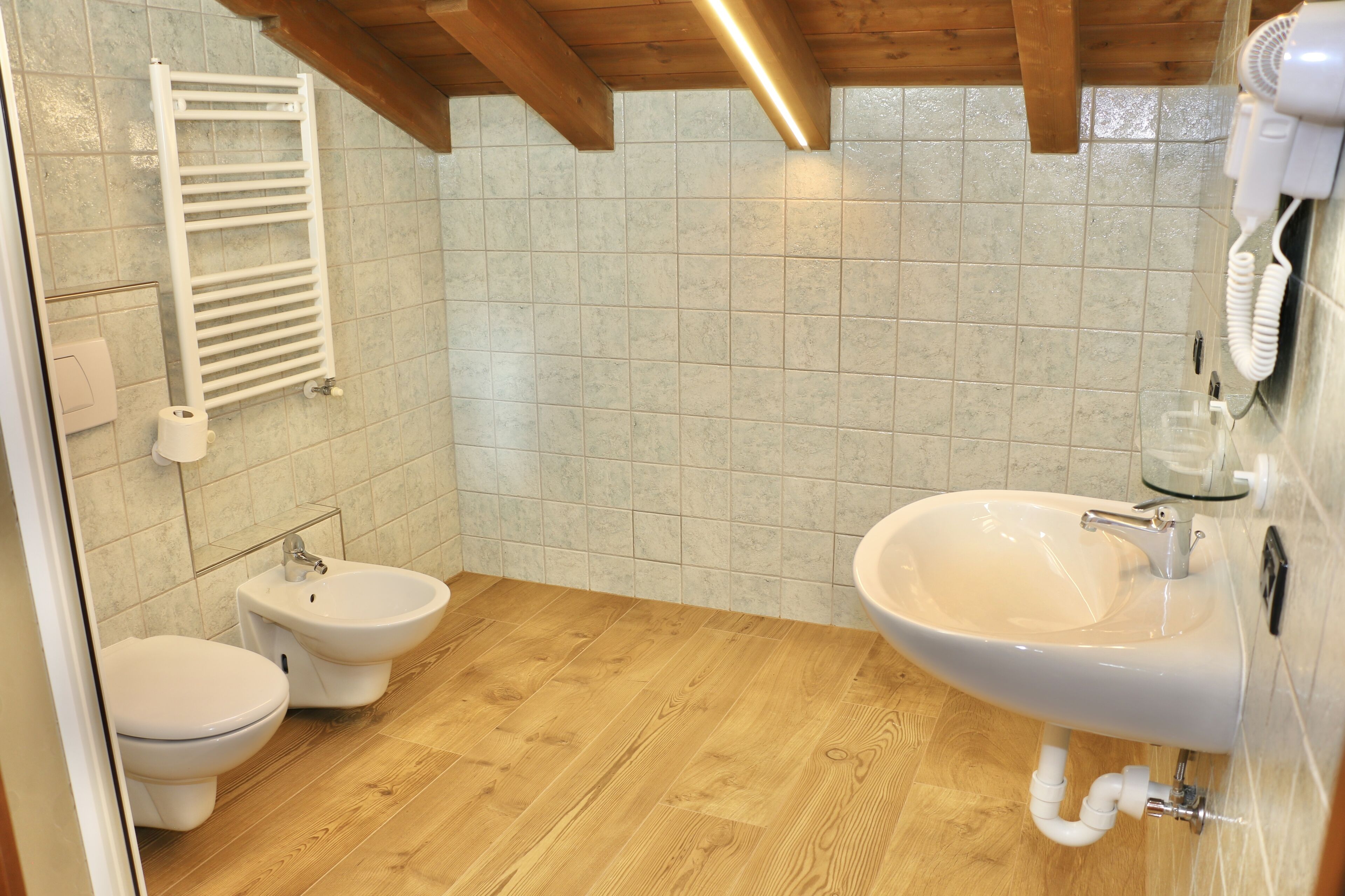 A bathroom with a toilet, bidet, and sink.