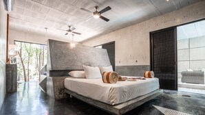 A modern bedroom with a large bed, a ceiling fan, and a view of the outdoors. - CASA T -  Chic, Modern Villa with 3 Master Suites, AC & Pool  (Tulum)