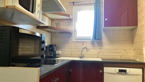 A compact kitchen with a microwave, coffee maker, and dishwasher.