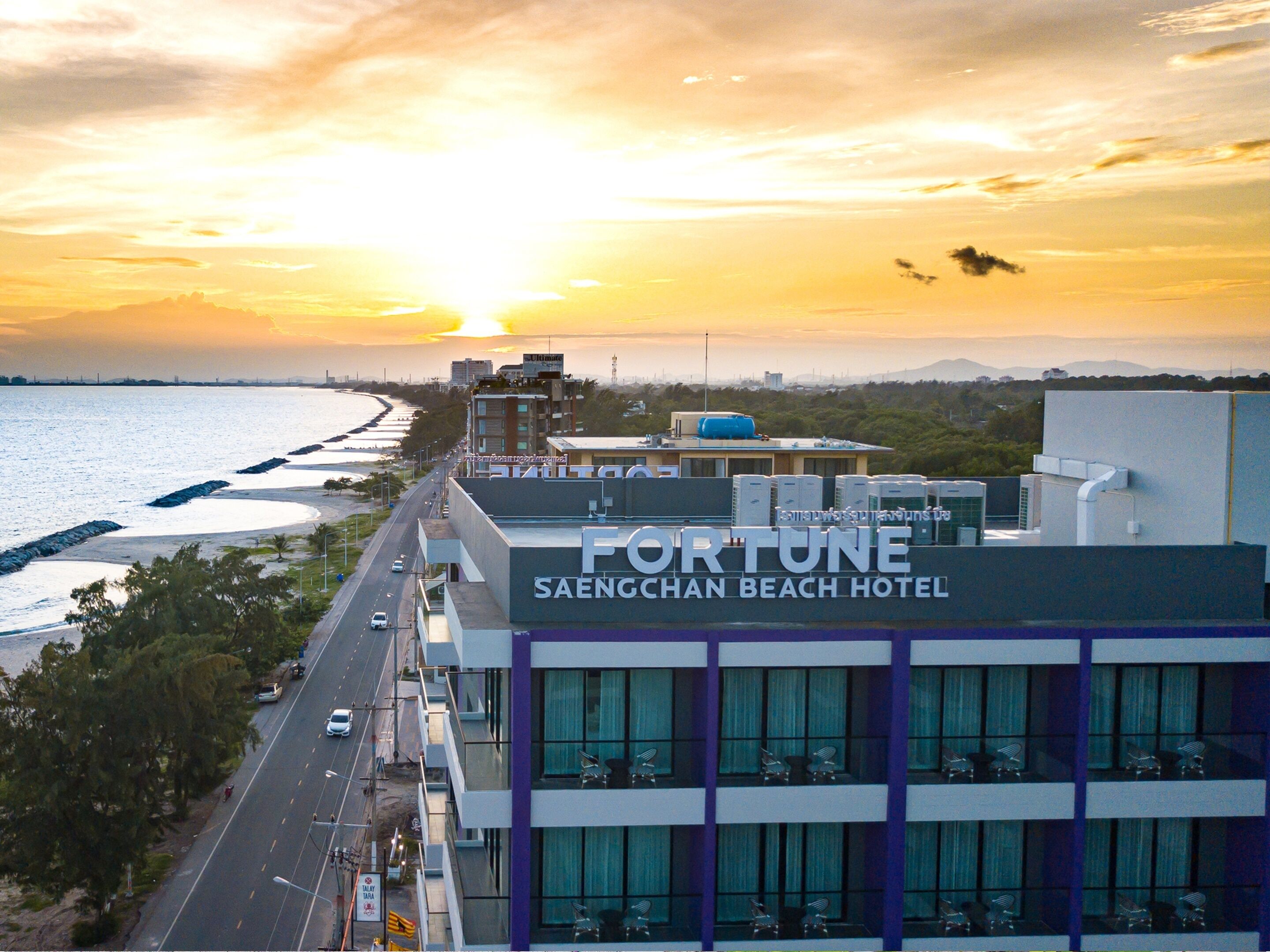 The Fortune Saenchan Beach Hotel with a view of the beach and sunset.