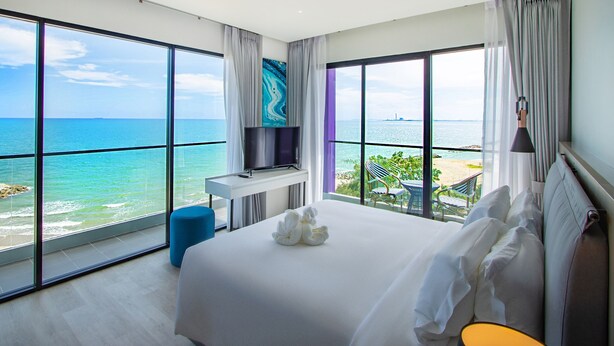 A modern hotel room with a large bed, a flat-screen TV, and a view of the ocean. - Fortune Saeng Chan Beach Hotel Rayong (Rayong)