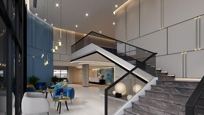 A modern interior with a staircase, seating area, and a reception desk. - Fortune Saeng Chan Beach Hotel Rayong (Rayong)