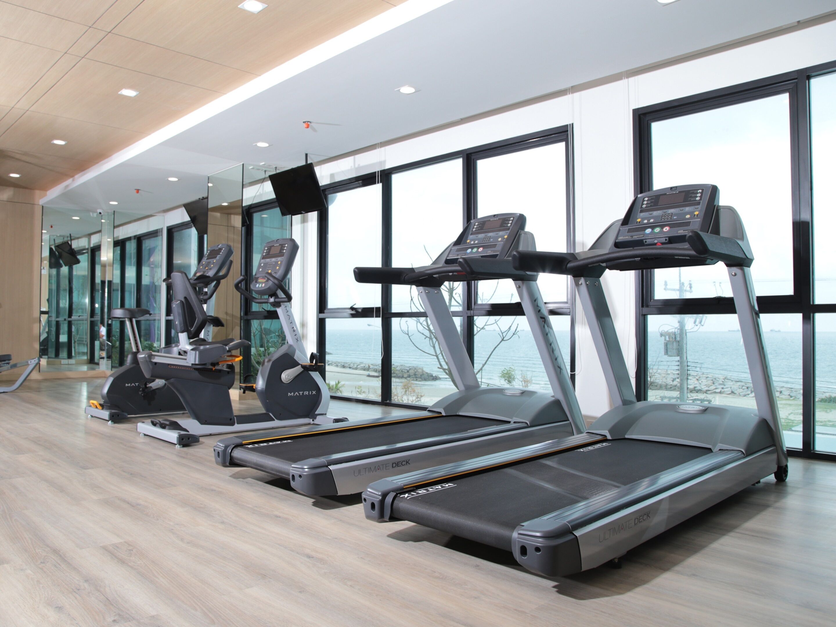 Un gimnasio con cintas de correr, bicicletas estáticas y elípticas.