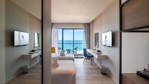 A modern hotel room with a large balcony, two beds, a desk, and a TV. - Fortune Saeng Chan Beach Hotel Rayong (Rayong)