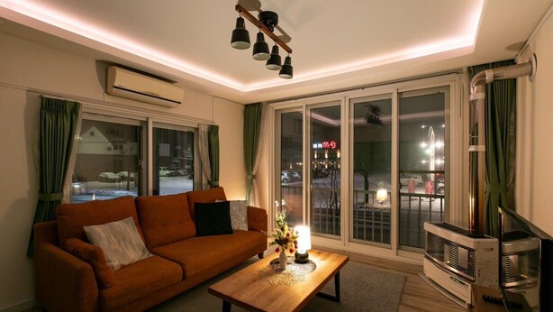 Een woonkamer met een bank, een salontafel en een tv-meubel.