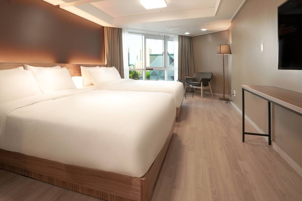 Una habitación de hotel con una cama grande, un escritorio y una silla.