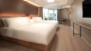 A hotel room with a large bed, a desk, and a chair.