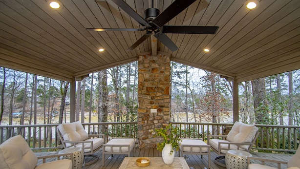 A covered outdoor seating area with stone pillars, wooden ceiling, and ceiling fan. - Upscale Lake Retreat on Large Private Lot, Expansive Deck, Boat Dock & Hot Tub! (Hot Springs)
