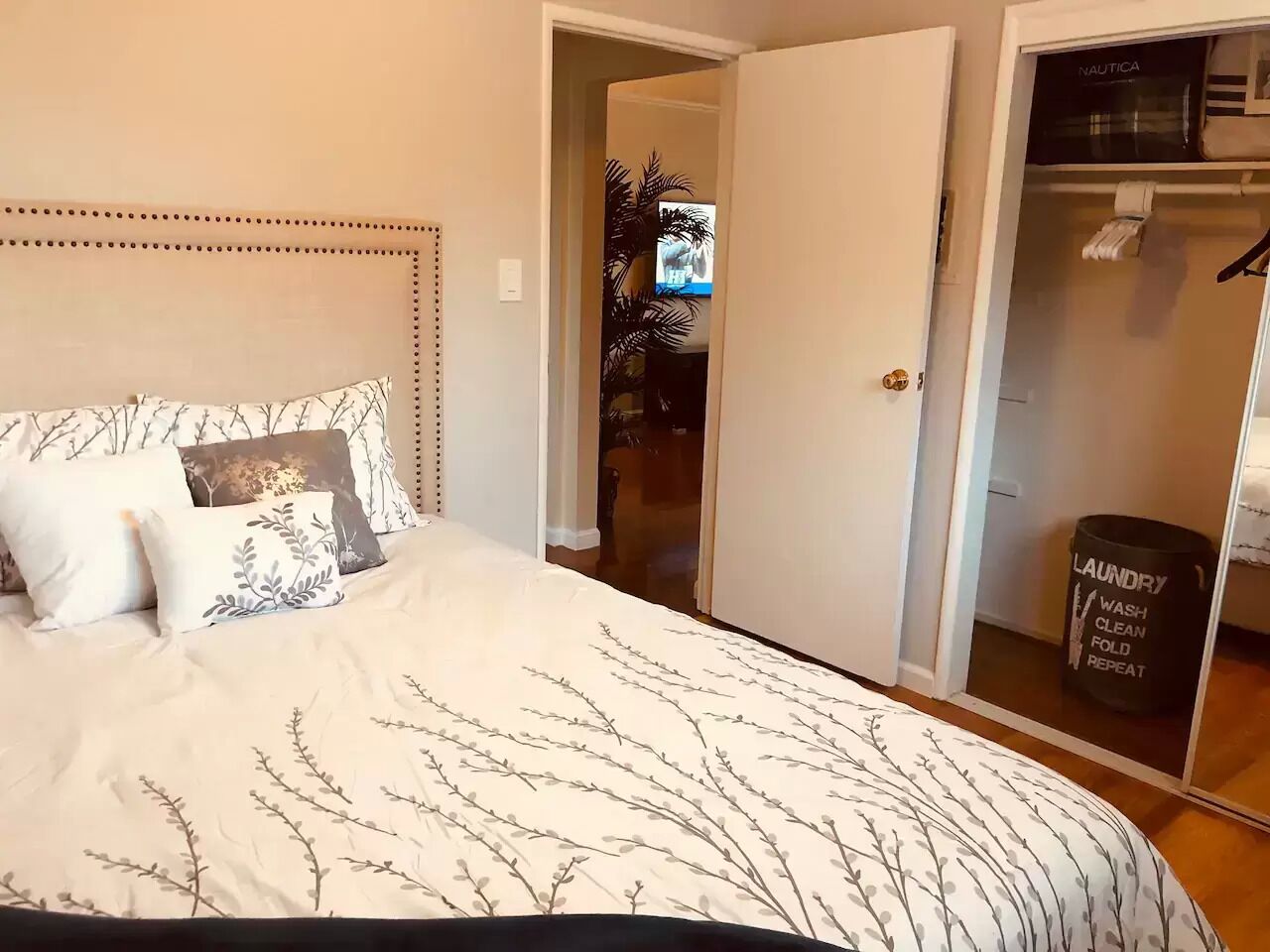 Un dormitorio con cama, armario y puerta que da a otra habitación.