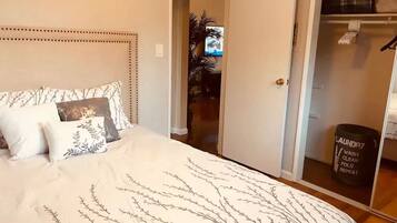 Un dormitorio con cama, armario y puerta que da a otra habitación.