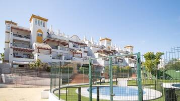 Un conjunto de edificios residenciales con varios balcones, piscina y zona exterior vallada.
