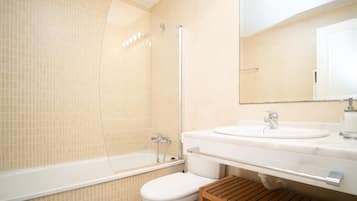 Un baño moderno con bañera, inodoro y lavamanos.