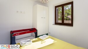 Ein kleiner Raum mit einem Bett, einem Fenster und einem Tisch mit Handtüchern.