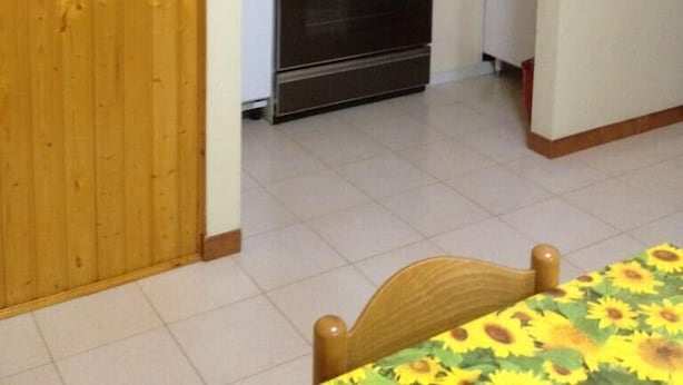 A compact kitchen with white cabinets, a stove, and a small refrigerator. - Bosamarina House (Bosa)
