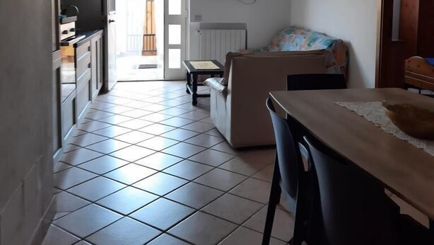 A compact living space with a kitchen, dining area, and a sofa. - Magomadas Enjoy House (Magomadas)