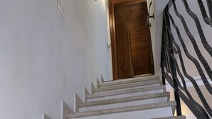 A staircase with white steps leading to a wooden door.