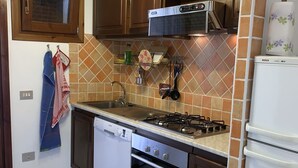 A kitchen with a Bosch dishwasher, a Bosch refrigerator, a gas stove, and a microwave.