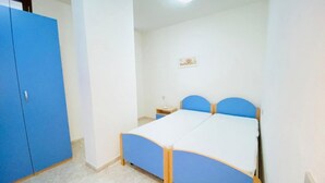 Un dormitorio con cama, armario y mesita de noche.