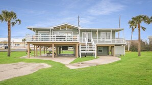 Une maison à deux étages dotée d’un patio couvert et d’une petite terrasse.