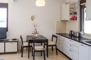 Deluxe Apartment | Private kitchen | Stovetop, electric kettle, cookware/dishes/utensils, cleaning supplies - Apartments Lumiere (Becici)