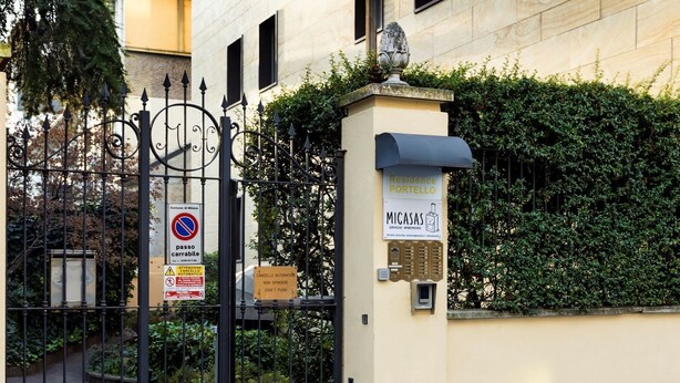 A gated entrance with a no parking sign, a mailbox, and a sign for 'MICASAS Serviced Apartments'. - Residence Portello (Milan)