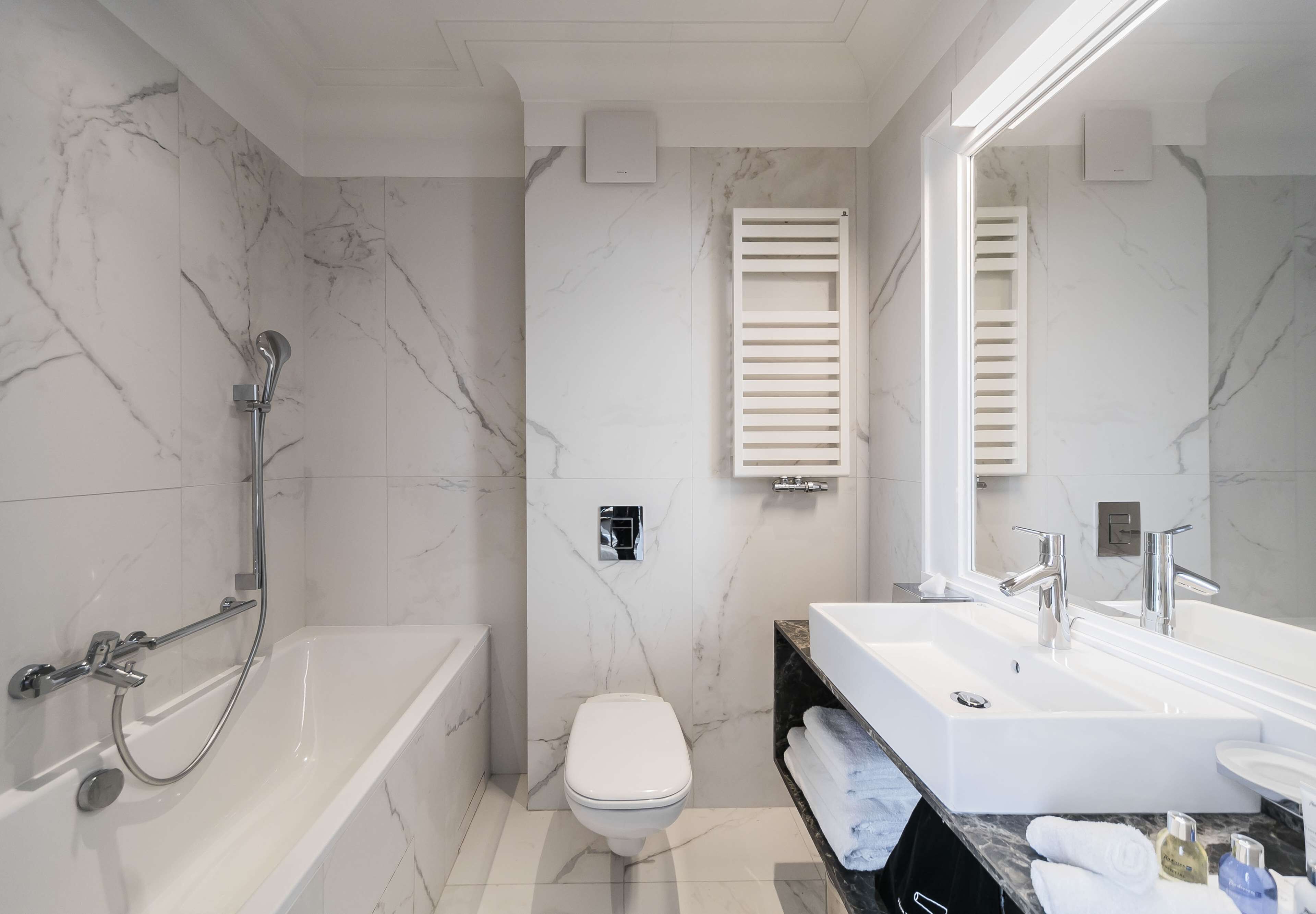 Ein modernes Badezimmer mit Badewanne, Toilette und Waschtisch mit Spiegel.