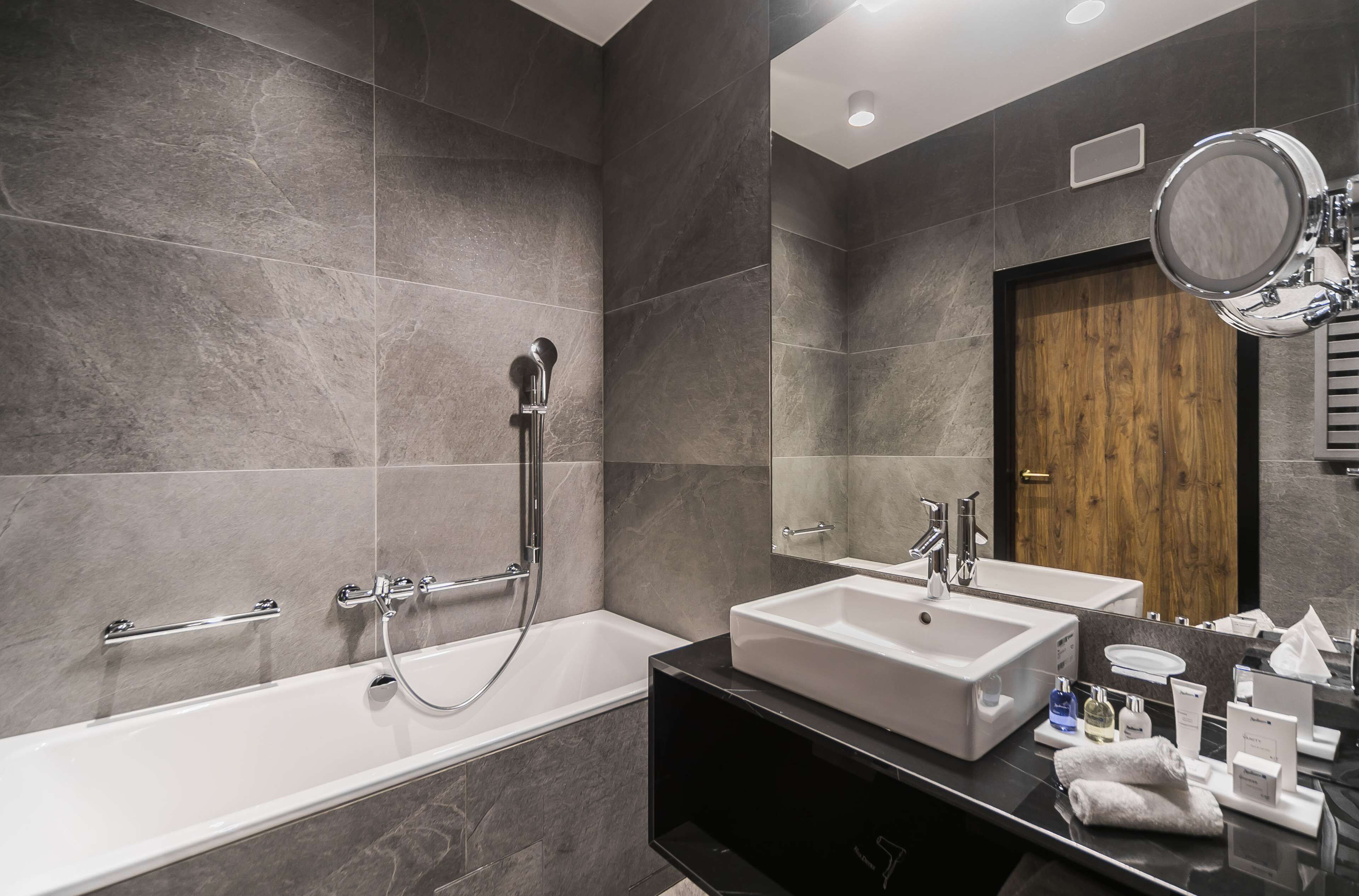 Ein modernes Badezimmer mit einer Badewanne, zwei Waschbecken, einem Waschtisch und einem Spiegel.