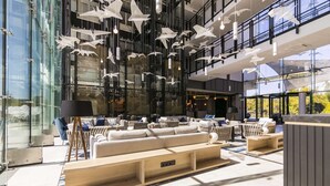 A modern lounge area with seating, a coffee table, and hanging light fixtures. - Radisson Blu Hotel Sopot (Sopot)