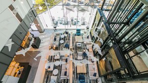 A modern atrium with multiple seating areas, including sofas and tables, arranged in a spacious layout. - Radisson Blu Hotel Sopot (Sopot)