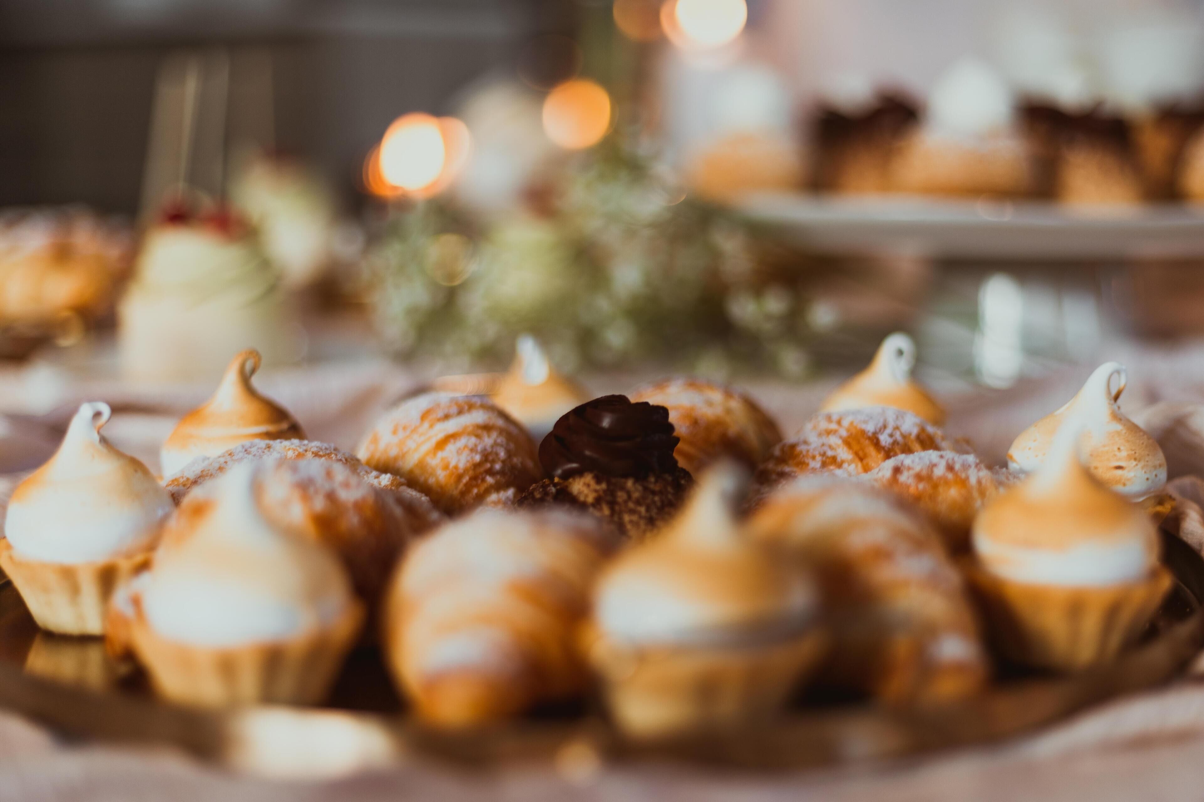 A variety of pastries on a table, including meringues and a chocolate dessert.