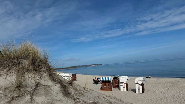 A beach with sand dunes, beach chairs, and a small structure. - Reethaus Boddenblick in Alt Reddevitz with parking lot, ground-level terrace, Wgh12 (Alt Reddevitz)
