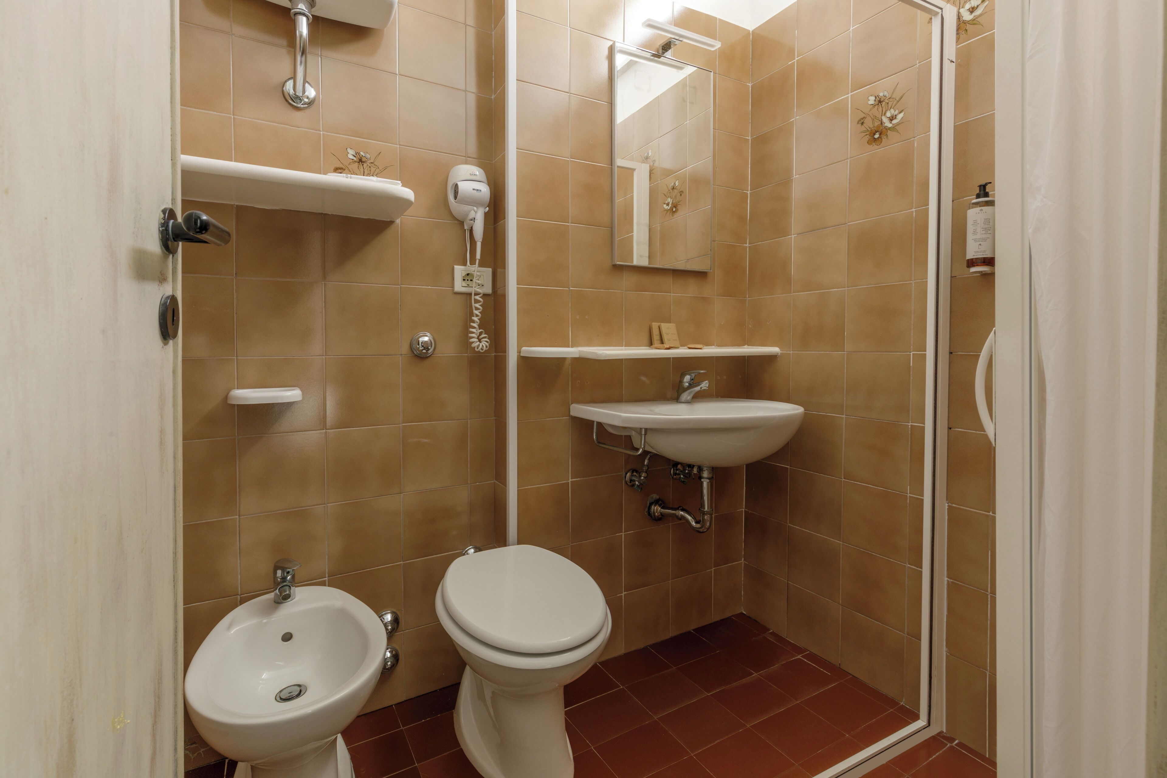 A bathroom with a toilet, sink, and shower.