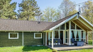 A single-story house with a sloped roof, a covered porch with outdoor seating, and a satellite dish. - 6 Person Holiday Home in Vig (Vig)