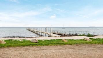 A gravel path leading to a wooden pier extending into the water.