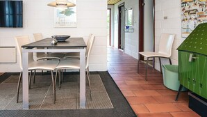 Ett modernt matområde med ett bord, stolar och en hängande lampa.