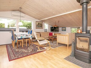 Cozy room with a dining area, sofa, and fireplace, offering a view of the outdoors.