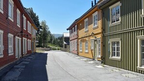 A narrow street lined with traditional wooden buildings, some with visible signage. - Holiday Home in Bjorli (Lesja)